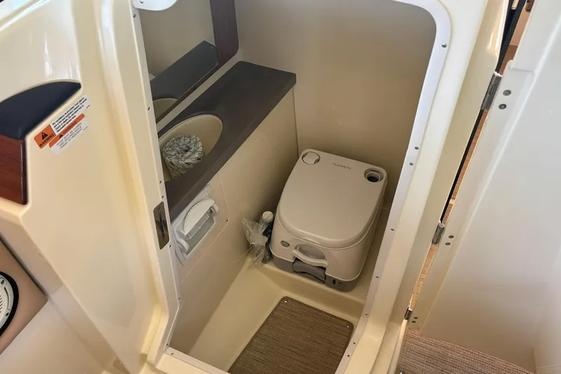 Slide: The Image of 2023 Chris-Craft Calypso 24 boat interior with compact marine toilet and sink. - 29