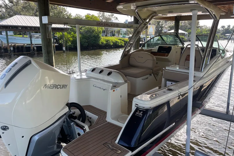 Slide: The Image of 2023 Chris-Craft Calypso 24 boat with Mercury engine docked in a scenic marina. - 3