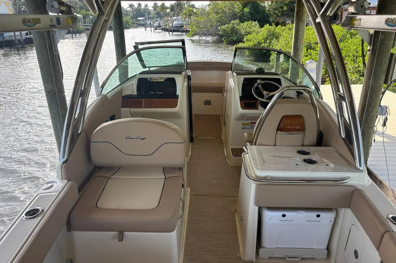 Slide: The Image of 2023 Chris-Craft Calypso 24 boat interior with seating and steering wheel, docked by water. - 5
