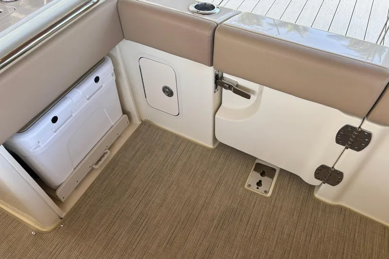 Slide: The Image of 2023 Chris-Craft Calypso 24 interior with storage compartment and cushioned seating. - 8