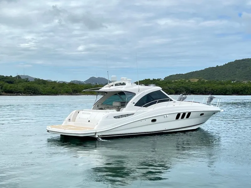 Slide: The Image of 2006 Sea Ray 48 Sundancer on calm water with green landscape. - 11