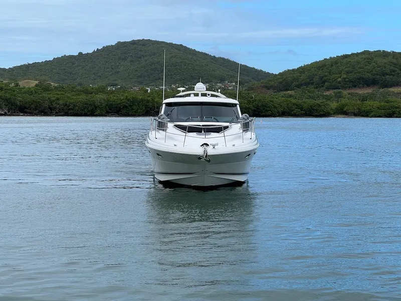 Slide: The Image of 2006 Sea Ray 48 Sundancer on calm water with green hills. - 20