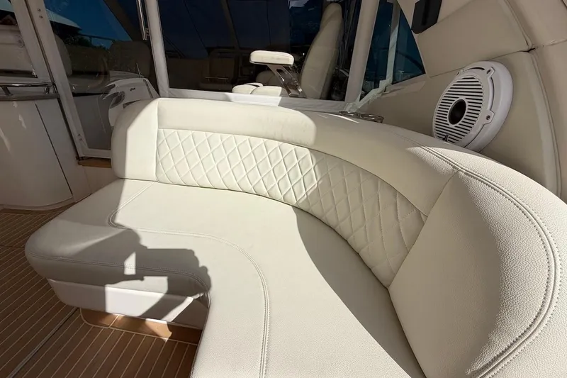 Slide: The Image of Luxurious white seating on 2006 Sea Ray 48 Sundancer yacht, featuring quilted upholstery and speaker. - 29