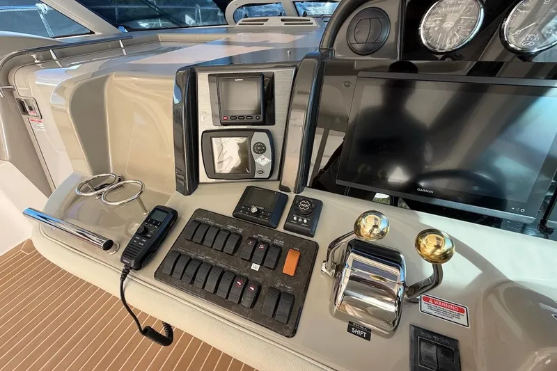 Slide: The Image of Control panel of a 2006 Sea Ray 48 Sundancer yacht with navigation and throttle controls. - 37