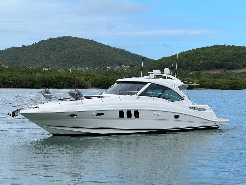 Slide: The Image of 2006 Sea Ray 48 Sundancer on calm water with green hills. - 4