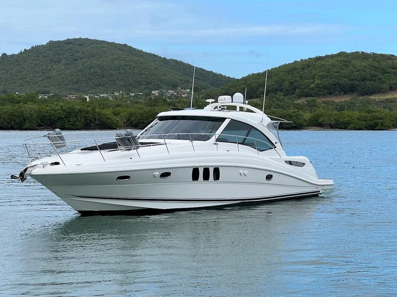 Slide: The Image of 2006 Sea Ray 48 Sundancer on calm water with green hills. - 5