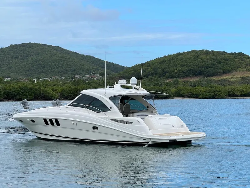 Slide: The Image of 2006 Sea Ray 48 Sundancer on calm water with green hills. - 7