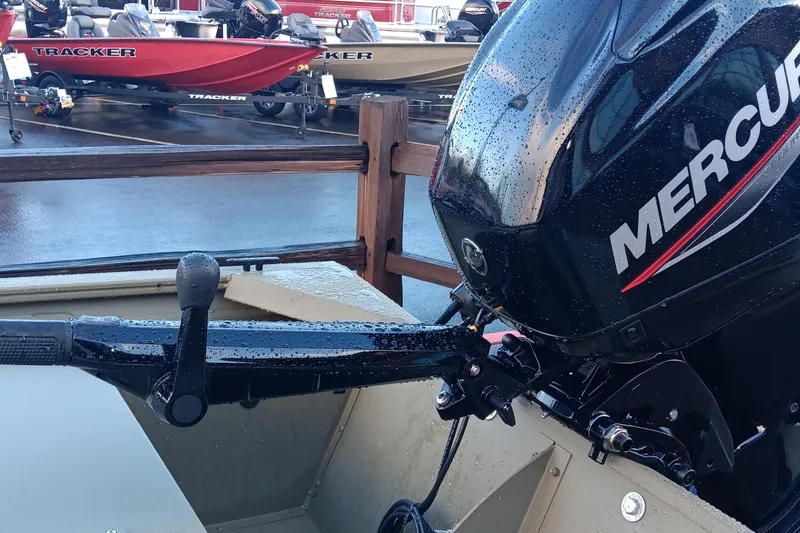 Slide: The Image of 2026 Tracker Grizzly 1648 Utility boat with Mercury outboard motor in a showroom. - 2