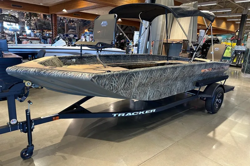 The Image of 2026 Tracker Grizzly 1756 T Marsh boat with camouflage design on display indoors. - 0