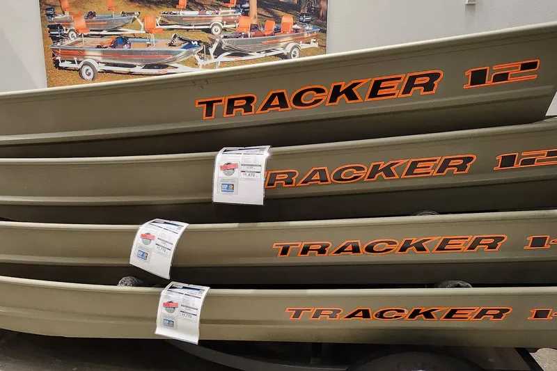 The Image of Stacked Tracker Grizzly 14 Jon boats, 2026 model, displayed in a showroom. - 0