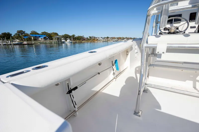 Slide: The Image of 2006 Edgewater 228CC boat interior with steering wheel, docked by calm waters. - 10