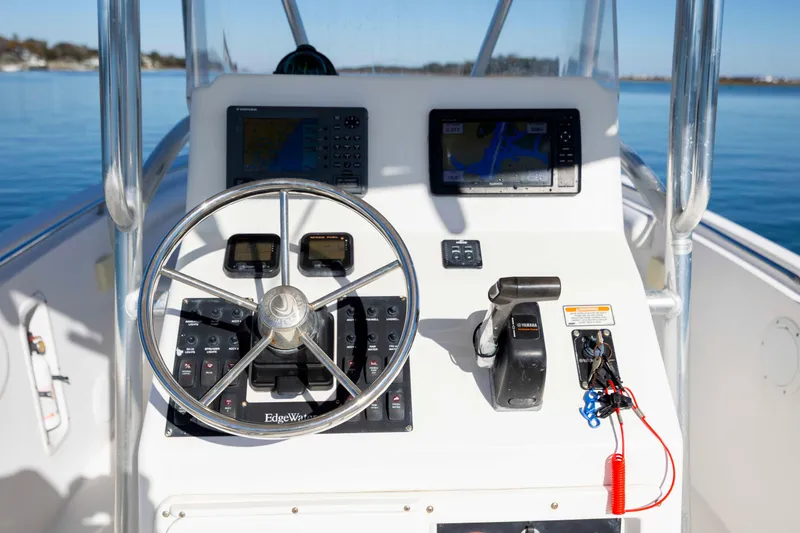 Slide: The Image of Edgewater 228CC 2006 boat console with steering wheel and navigation equipment. - 13