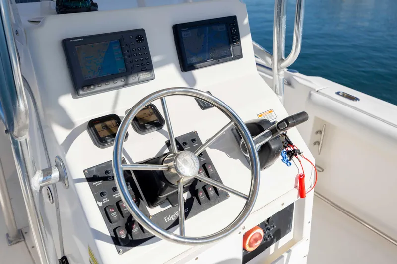 Slide: The Image of 2006 Edgewater 228CC boat dashboard with steering wheel and navigation equipment. - 14