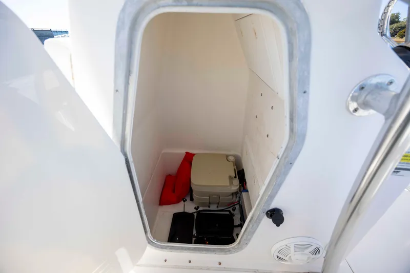Slide: The Image of Storage compartment in 2006 Edgewater 228CC boat with life jacket and portable toilet. - 21