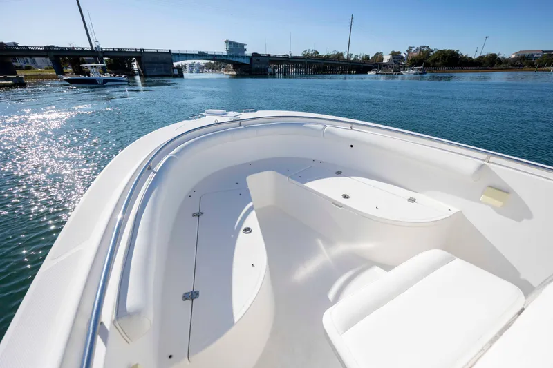 Slide: The Image of 2006 Edgewater 228CC boat on calm water near a bridge, sunny day. - 22
