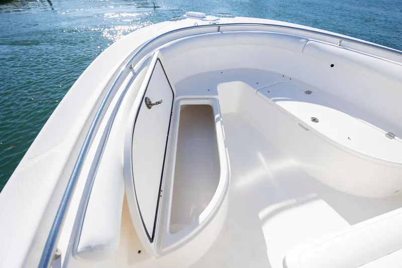 Slide: The Image of 2006 Edgewater 228CC boat interior with open storage compartment on calm water. - 23