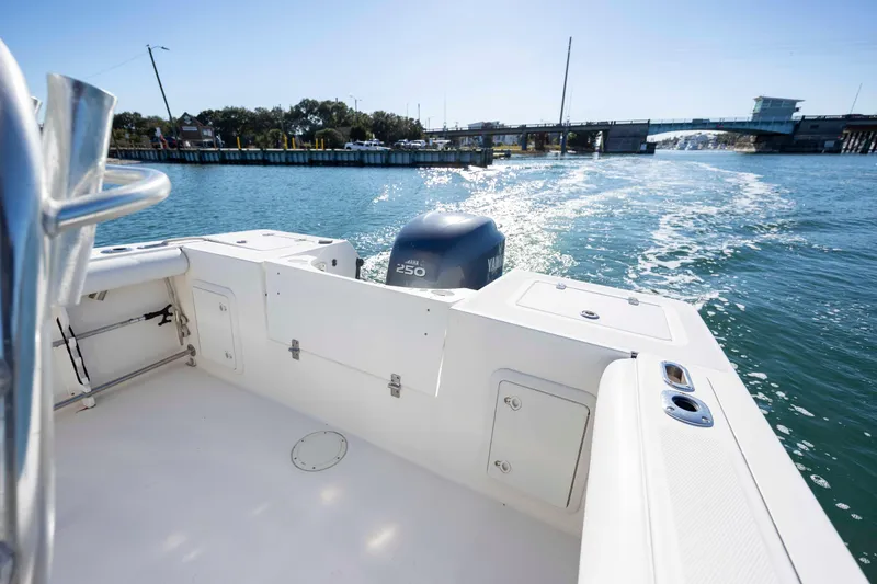Slide: The Image of 2006 Edgewater 228CC boat cruising on a sunny day near a bridge. - 7