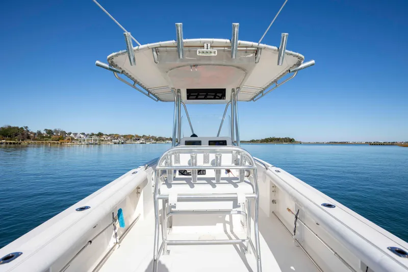 Slide: The Image of 2006 Edgewater 228CC boat on calm water, clear sky, and scenic shoreline. - 9