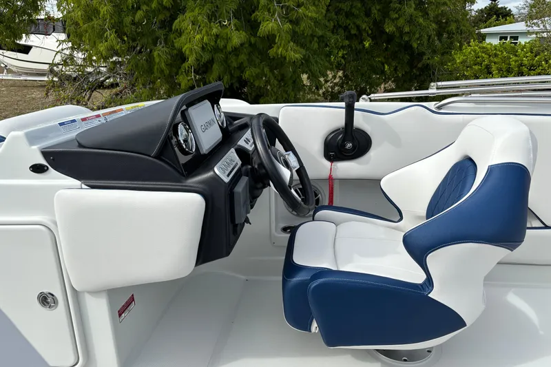 Slide: The Image of 2026 Crownline Eclipse E210 XS boat cockpit with blue and white seating and Garmin navigation. - 11