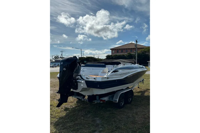 Slide: The Image of 2026 Crownline Eclipse E210 XS boat on trailer under a partly cloudy sky. - 15