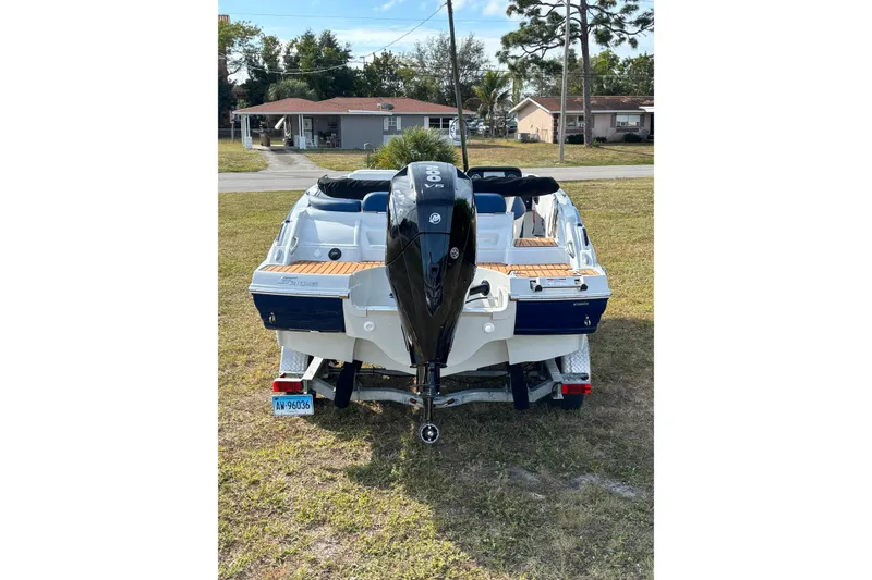 Slide: The Image of 2026 Crownline Eclipse E210 XS boat on trailer, rear view, parked on grass. - 16