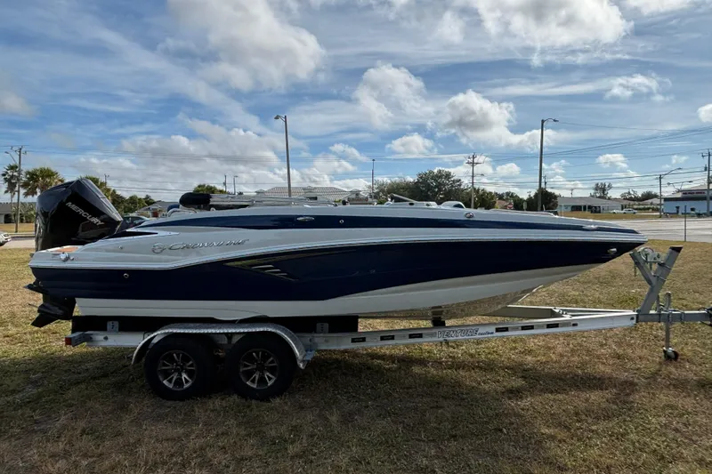 Slide: The Image of 2026 Crownline Eclipse E210 XS boat on trailer under cloudy sky. - 21
