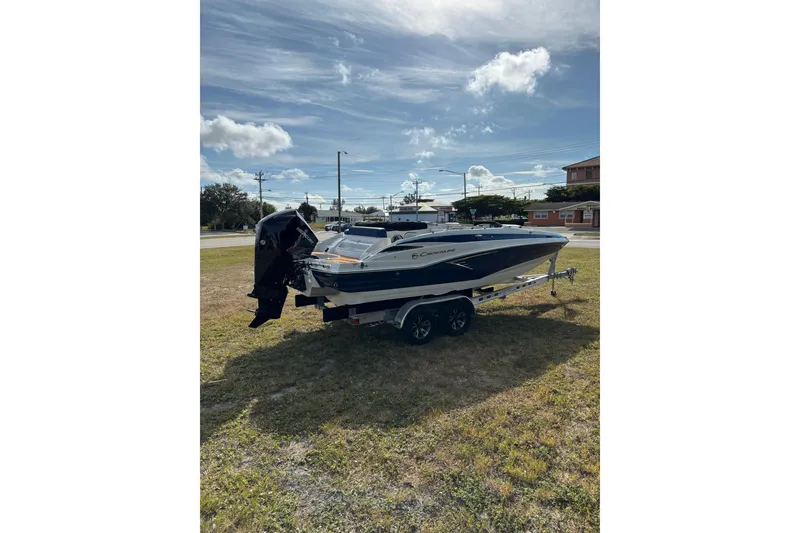 Slide: The Image of 2026 Crownline Eclipse E210 XS boat on trailer under a sunny sky. - 22