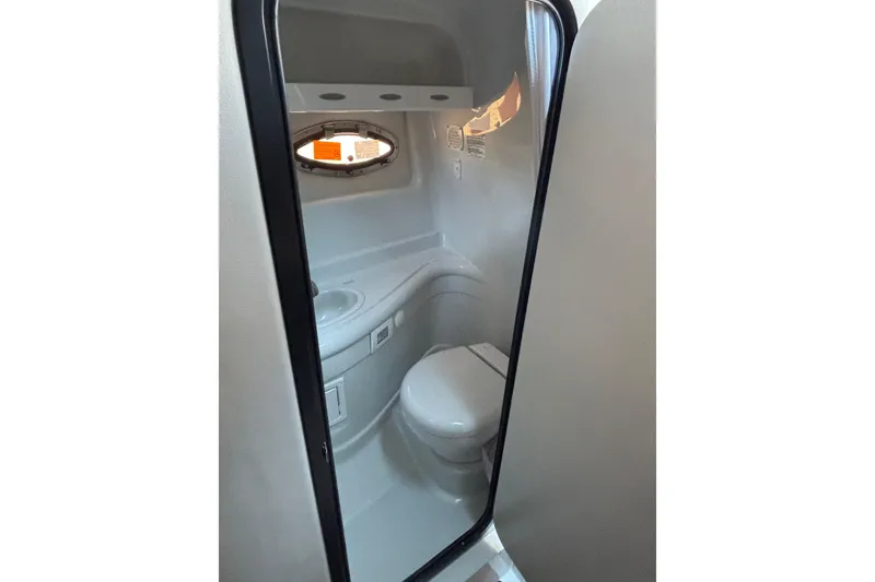 Slide: The Image of 2026 Crownline 280 CRX boat bathroom interior with toilet and sink. - 13