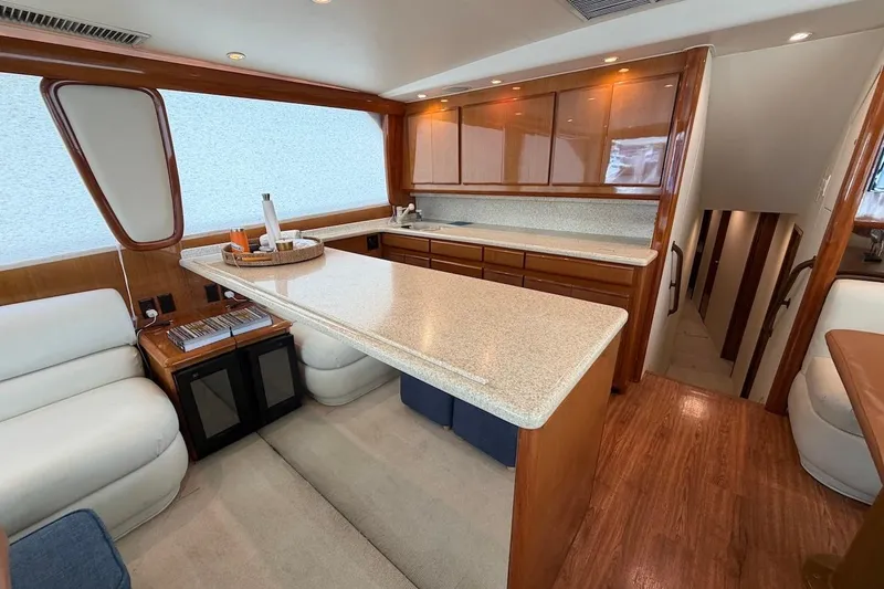 Slide: The Image of Luxurious interior of 1999 Viking 58 Convertible yacht with modern kitchen and seating area. - 11
