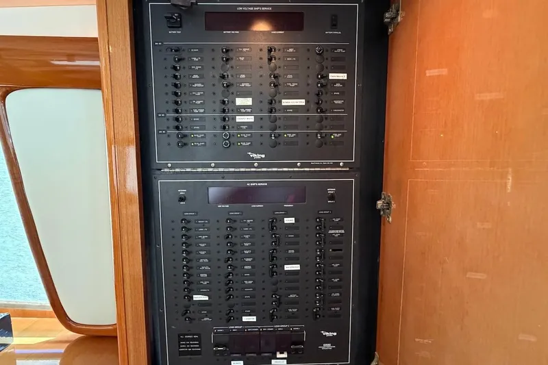 Slide: The Image of Electrical panel inside 1999 Viking 58 Convertible yacht, showcasing control switches and circuit breakers. - 16