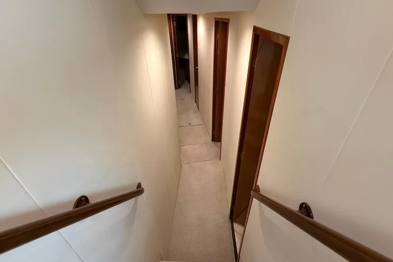 Slide: The Image of Interior hallway of a 1999 Viking 58 Convertible yacht with wooden doors and handrails. - 18