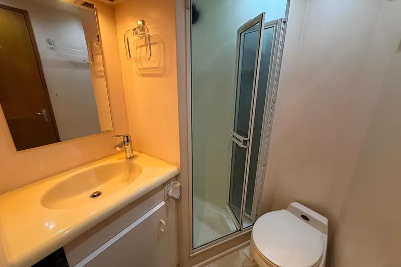 Slide: The Image of Bathroom interior of 1999 Viking 58 Convertible yacht with sink, shower, and toilet. - 24