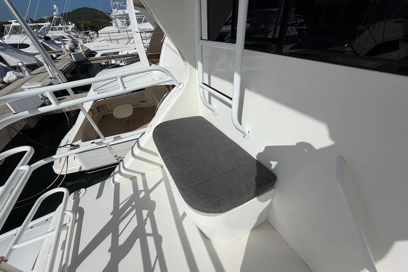 Slide: The Image of 1999 Viking 58 Convertible yacht with cushioned seating on deck, docked at marina. - 38