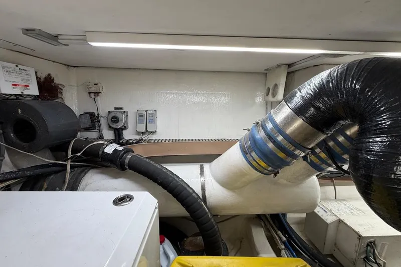 Slide: The Image of Engine room of a 1999 Viking 58 Convertible yacht with visible exhaust system and wiring. - 46