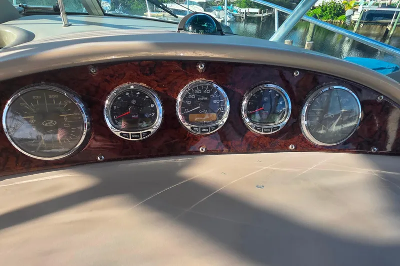 Slide: The Image of 2006 Sea Ray 290 Amberjack cockpit with Garmin navigation, surrounded by lush greenery. - 14