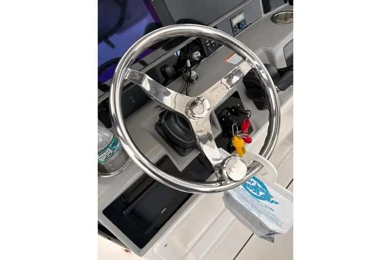 Slide: The Image of Steering wheel of 2023 Robalo R250 Center Console boat, featuring modern controls. - 15