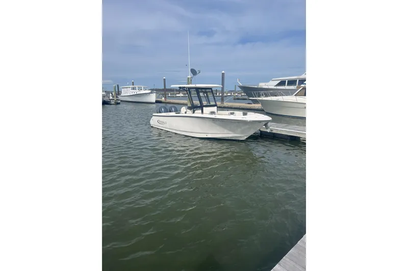 Slide: The Image of 2023 Robalo R250 Center Console boat docked in a marina under a clear sky. - 19