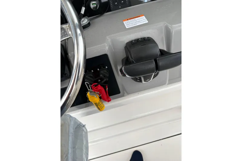Slide: The Image of 2023 Robalo R250 Center Console helm with steering wheel and throttle controls. - 21