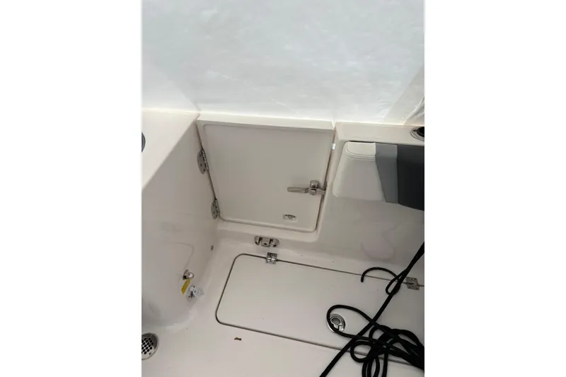 Slide: The Image of 2023 Robalo R250 Center Console interior with storage compartments and marine equipment. - 22