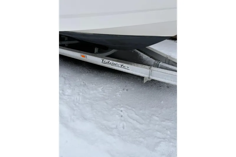 Slide: The Image of 2023 Robalo R250 Center Console boat on a Tidewater trailer in snowy conditions. - 24