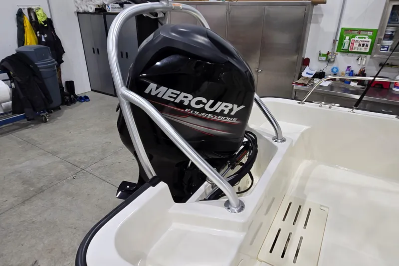 Slide: The Image of 2014 Boston Whaler 170 Montauk with Mercury FourStroke engine in a garage setting. - 12