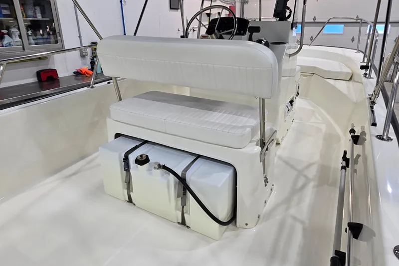 Slide: The Image of 2014 Boston Whaler 170 Montauk interior with white seating and storage compartment. - 13