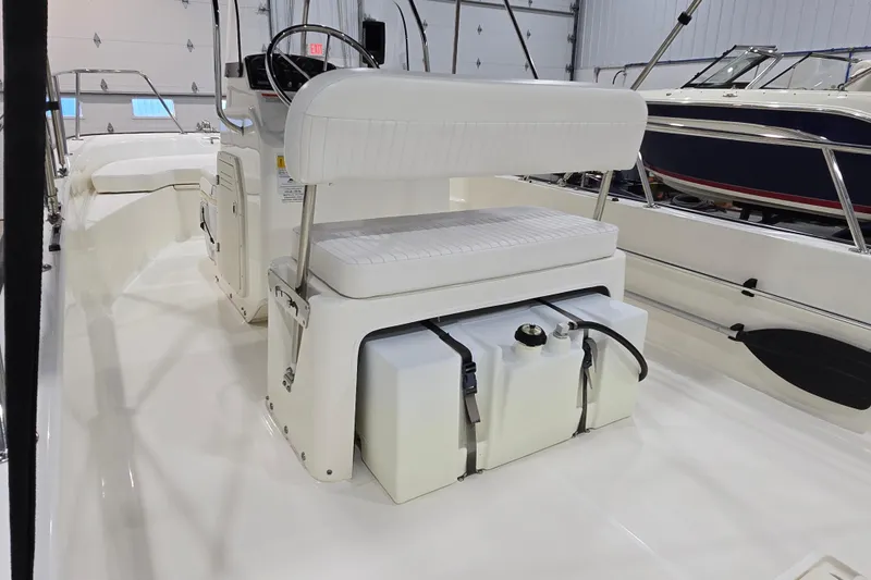 Slide: The Image of 2014 Boston Whaler 170 Montauk interior with seating and storage in a showroom. - 14