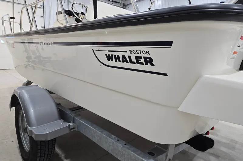 Slide: The Image of 2014 Boston Whaler 170 Montauk boat on trailer in indoor storage. - 17