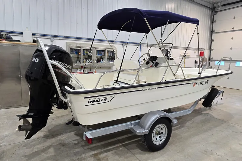 Slide: The Image of 2014 Boston Whaler 170 Montauk boat with Mercury engine in a garage. - 2