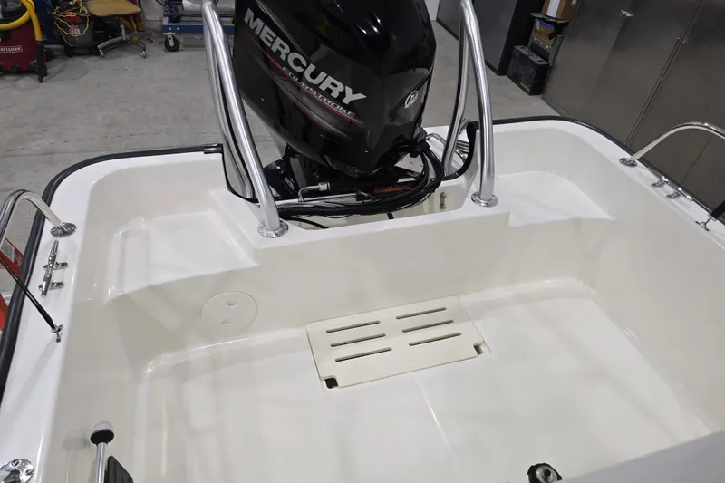 Slide: The Image of 2014 Boston Whaler 170 Montauk boat with Mercury engine in a garage setting. - 38