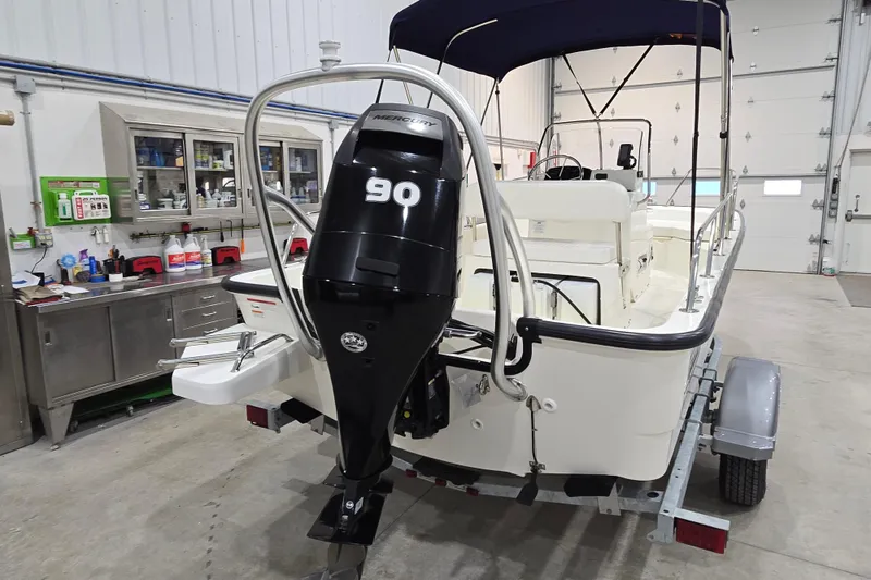 Slide: The Image of 2014 Boston Whaler 170 Montauk boat with 90 HP Mercury engine in a garage. - 4