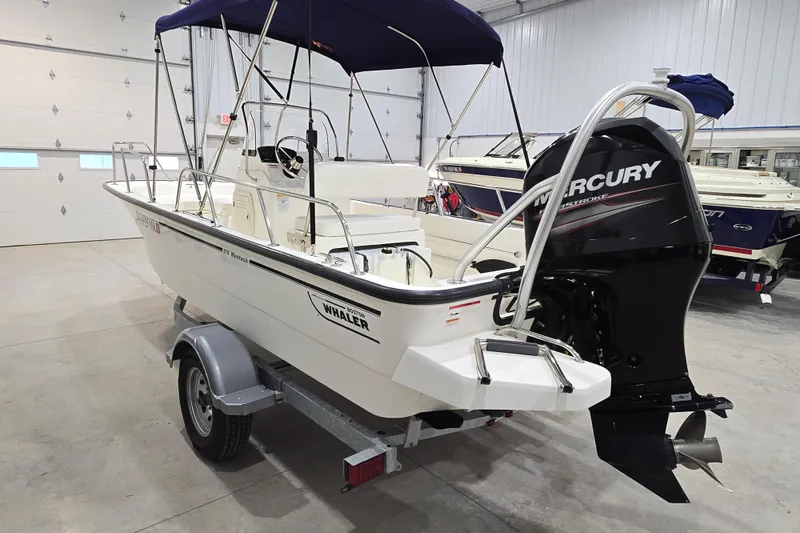 Slide: The Image of 2014 Boston Whaler 170 Montauk boat with Mercury engine in indoor showroom. - 5