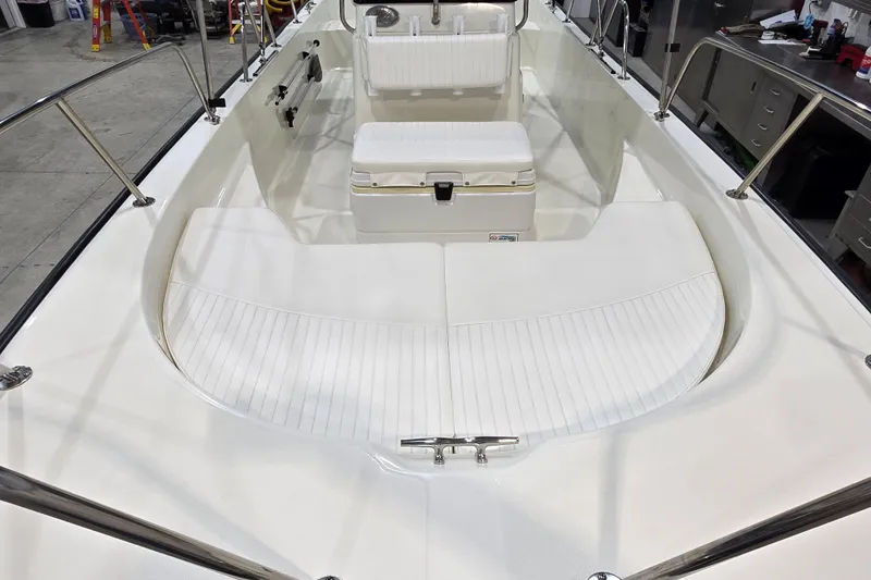 Slide: The Image of 2014 Boston Whaler 170 Montauk boat interior with white seating and stainless steel railings. - 9