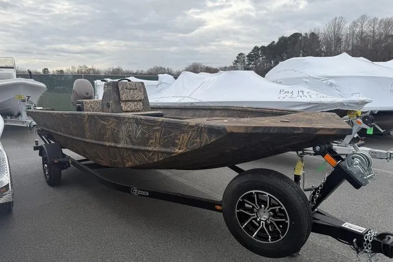 Slide: The Image of 2026 G3 Gator Tough 17 CC boat on trailer, camo design, parked outdoors. - 8